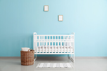 Baby crib near color wall in stylish children's room