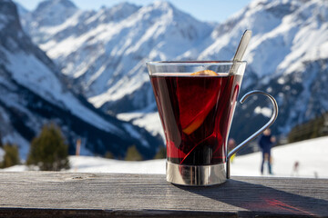 gros plan sur une tasse de vin chaud avec la montagne enneigée en arrière plan