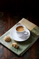 Cup of coffee with amaretti (Italian biscuits) on rustic wooden background. 