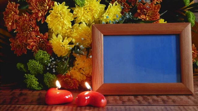 Valentines day romantic card. Wooden frame for your photos with chromakey (easy for insertion), chrysanthemum bunch, candles as hearts and gift box with bow on wooden background