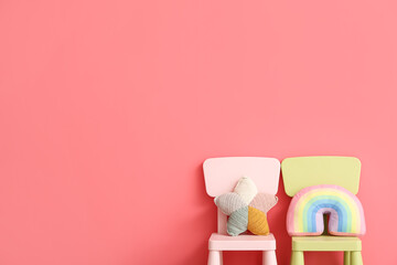Child chairs with cute toys on color background