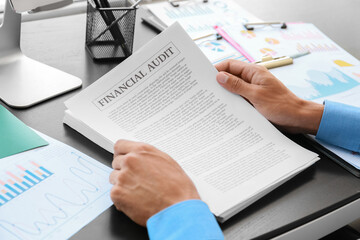 Businessman working with document at desk in office, closeup