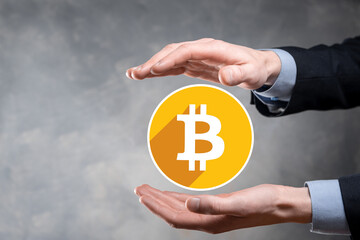 Male hand holding a bitcoin icon on grey background. Bitcoin Cryptocurrency Digital Bit Coin BTC Currency Technology Business Internet Concept