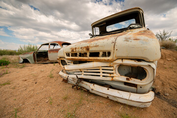 A horizontal shot of an abandoned vintage car wreck taken on a stormy afternoon in Solitaire, which...