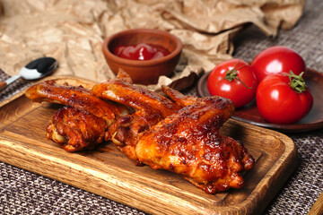 Homemade food grilled chicken wings with sauce and tomatoes