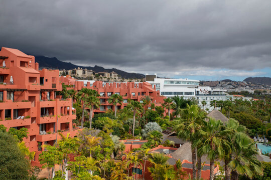 Overcast day in the busy, overbuilt resort with popular hotels surrounded by gardens and amenities from Mirador del Gaviota, Playa del Duque, Costa Adeje, Tenerife, Canary Islands, Spain