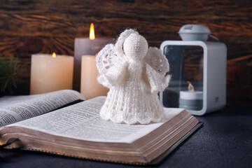 Book with angel toy on table. Christmas story