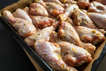 raw chicken drumsticks on baking tray prepared for oven