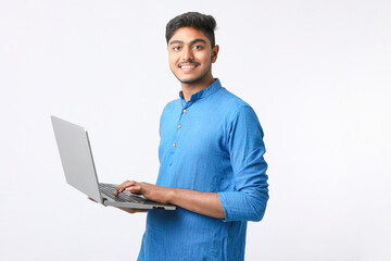 Young indian man using laptop on white background.