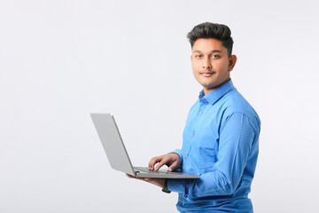 Young indian man using laptop over white background.