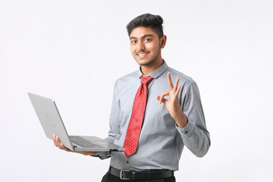 Young indian man using laptop on white background.