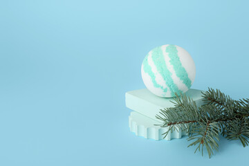 Composition with bath bomb and fir branch on blue background