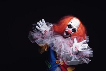 Terrifying clown on black background, space for text. Halloween party costume