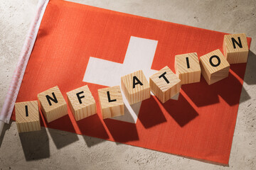 Switzerland flag and wooden cubes with text, concept on the theme of inflation in the country