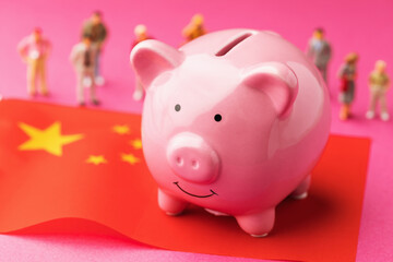 Piggy bank, Chinese flag and plastic toy men on a colored background, concept on the theme of income of the population of China