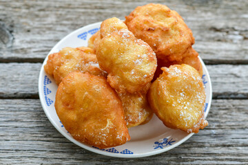 Traditional Bulgarian home made deep fried  patties  covered with sugar  оn rustic backgroud.Mekitsa or Mekica,  on wooden  rustic  background. Made of kneaded dough that is deep fried 