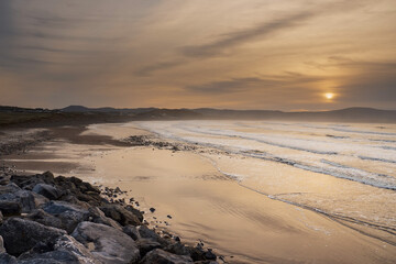 Strandhill beach at sunset. Sligo, Ireland. Big beach with stunning view and powerful ocean waves. Popular for surfing. Calm tranquil atmosphere.