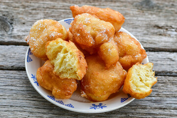 Traditional Bulgarian home made deep fried  patties  covered with sugar  оn rustic backgroud.Mekitsa or Mekica,  on wooden  rustic  background. Made of kneaded dough that is deep fried 