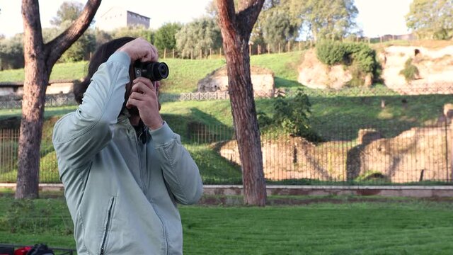 Young man traveling to Rome. The man is taking photographs of the monuments of Rome.
