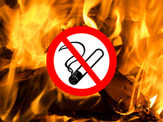 Close up der Flammen eines flackernden  Lagerfeuers mit eingefügtem Piktogramm Rauchen verboten