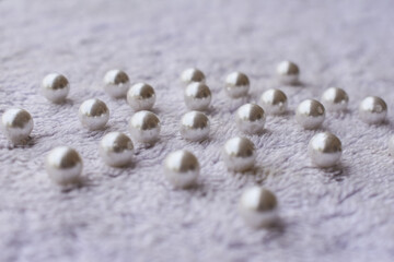 Fototapeta na wymiar many white pearl on white fur cloth surface