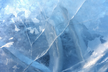 The texture of cracked ice on the surface of the lake. Ice pattern as a natural background.
