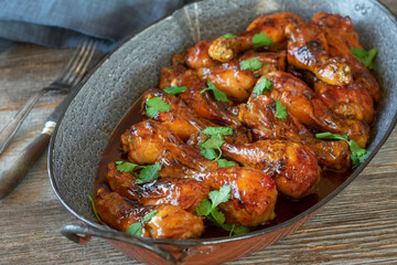 Honey glazed chicken drumsticks with barbecue sauce in a roasting pan