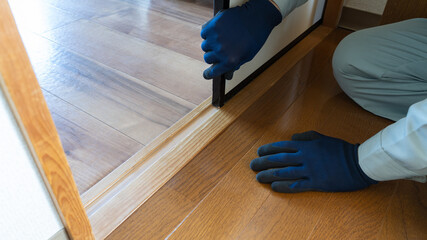 襖(ふすま)の修理・調整をする作業員