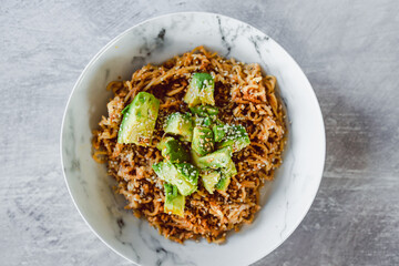 vegan ginger noodles with avocado sesame and fried onion topping, healthy plant-based food