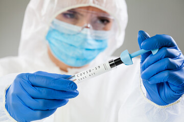 Female medical worker holding COVID-19 test kit
