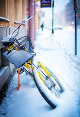 A bicycle stuck in the snow on the road in the city