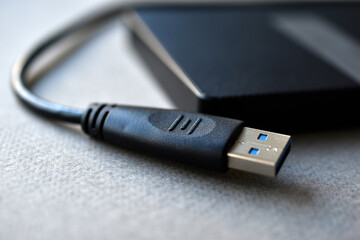 External hard drive with usb cable on a gray background