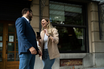 Young businesswoman and businessman standing on the street Beautiful businesswoman talking with her colleague