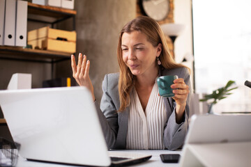 Obraz premium Happy businesswoman working on laptop. Portrait of beautiful businesswoman having video call.