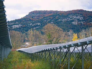 Irregularly shaped photovoltaic (solar) panels in the background of a mountain