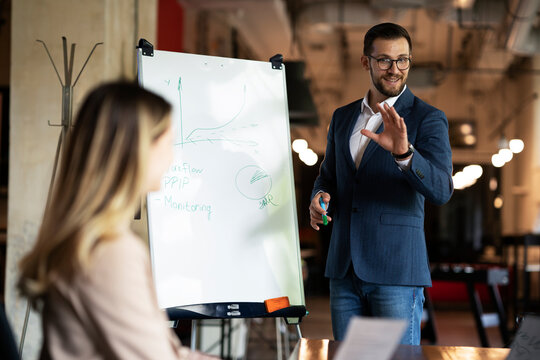 Businessman present his idea to working team. Young handsome man presenting businessplan..
