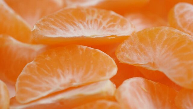Tangerine slices close-up. Camera moves along peeled pieces of tangerine