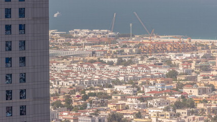 Construction site around Dubai water canal with pedestrian bridge over it aerial timelapse.