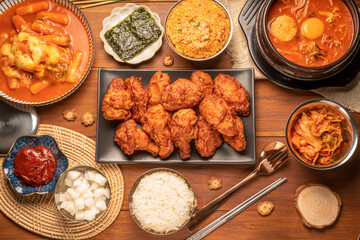 Traditional Korean food, Korean Fried chicken with spicy sauce  with rice, seaweed and Kimchi pickle on wooden table.