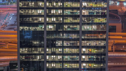 Fototapeta na wymiar Outside view of windows in offices of a high class building at night timelapse