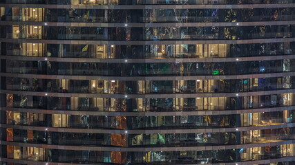 Fototapeta na wymiar Outside view of windows in apartments of a high class building at night timelapse