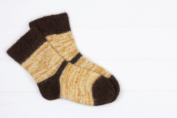 warm mens white knitted dog fur socks on white wooden background with copy space, top view