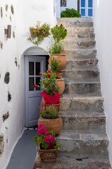 Fototapeta na wymiar Ceramic flower pots on steep stone steps at Imergovigli, Santorini, Greece