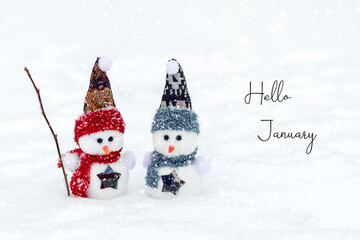 Merry christmas and happy new year greeting card with copy space Happy two little snowmen in red, blue cap and scarf standing in winter snow background Xmas fairytale Hello January, February concept