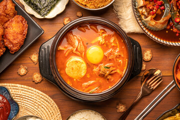 Traditional Korean food, kimchi soup, Korean Fried chicken with spicy sauce  with rice, seaweed,fresh raw crabs marinated,spicy Rice Cake and Kimchi pickle on wooden table.