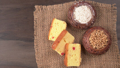 Slices of home made wholemeal bread on a white background with wheat and flour.