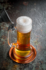 Light beer in a glass, on an old background.