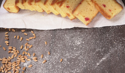 Slices of home made wholemeal bread on a white background with wheat and flour.