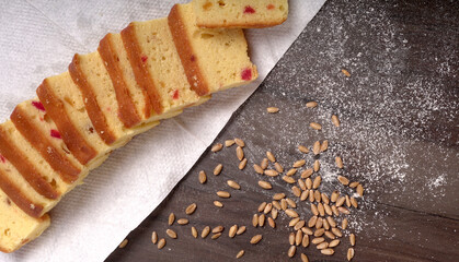 Slices of home made wholemeal bread on a white background with wheat and flour.