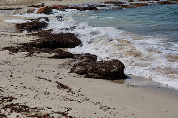 Waves against large rocks on the beach shore